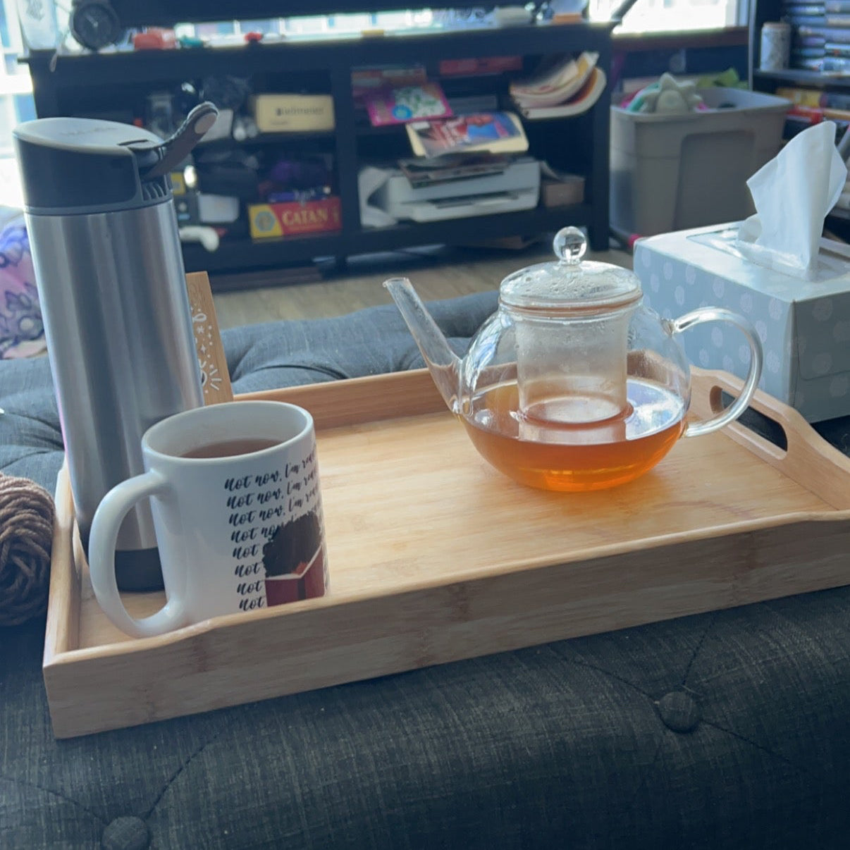 Tea set on a tray with a mug and teapot on a couch